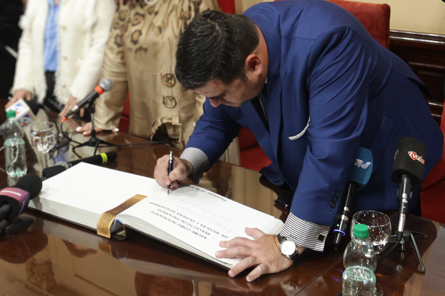 Intendente firmando libro