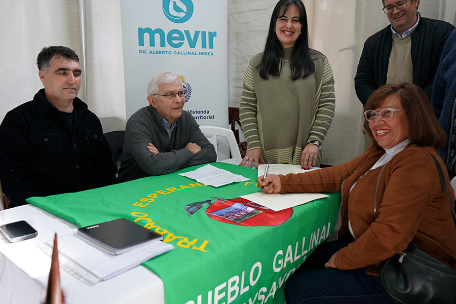 Vecina firmando títulos