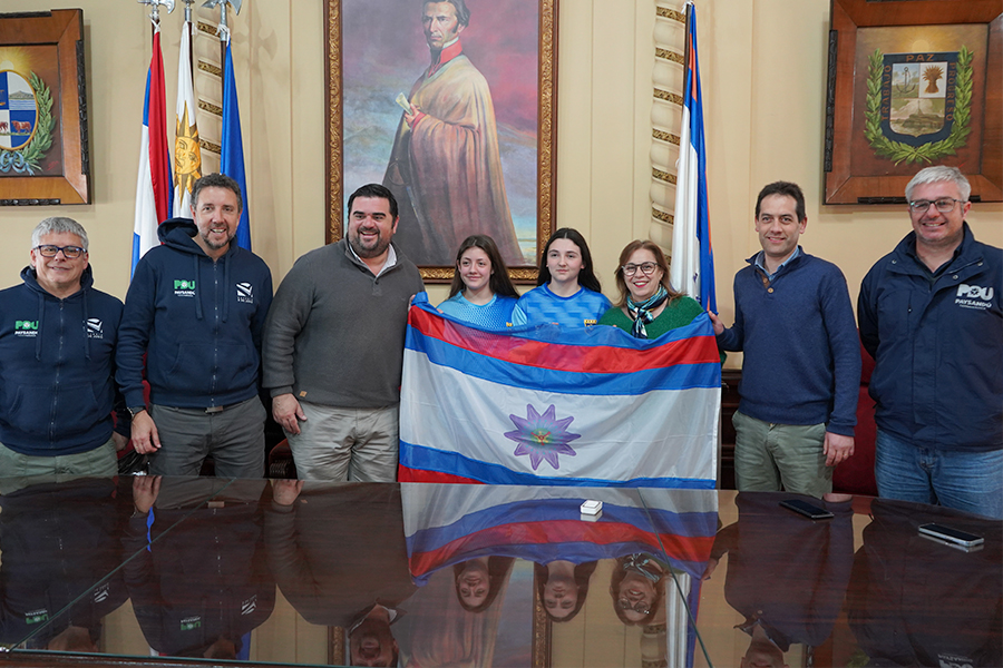 Intendente entregando bandera a las deportistas